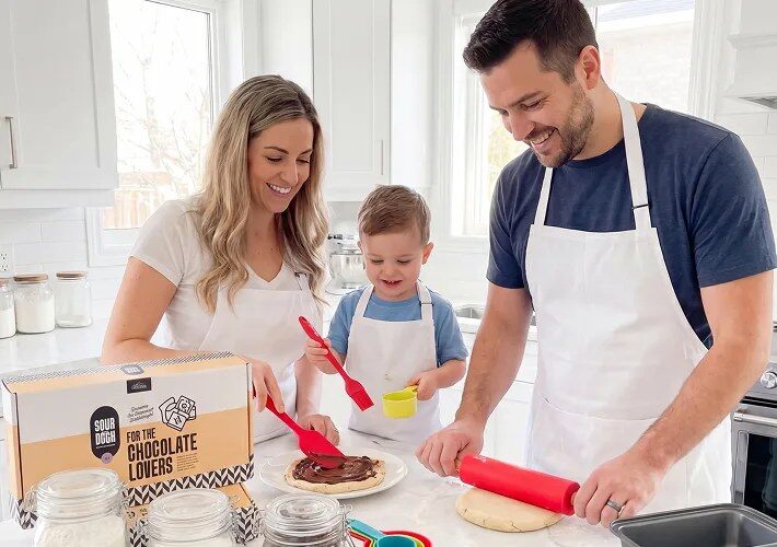 Parents and a toddler baking together with a Baketivity kit