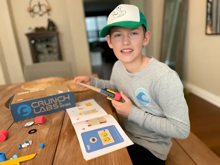 Kid building a CrunchLabs Build Box engineering toy at the kitchen table