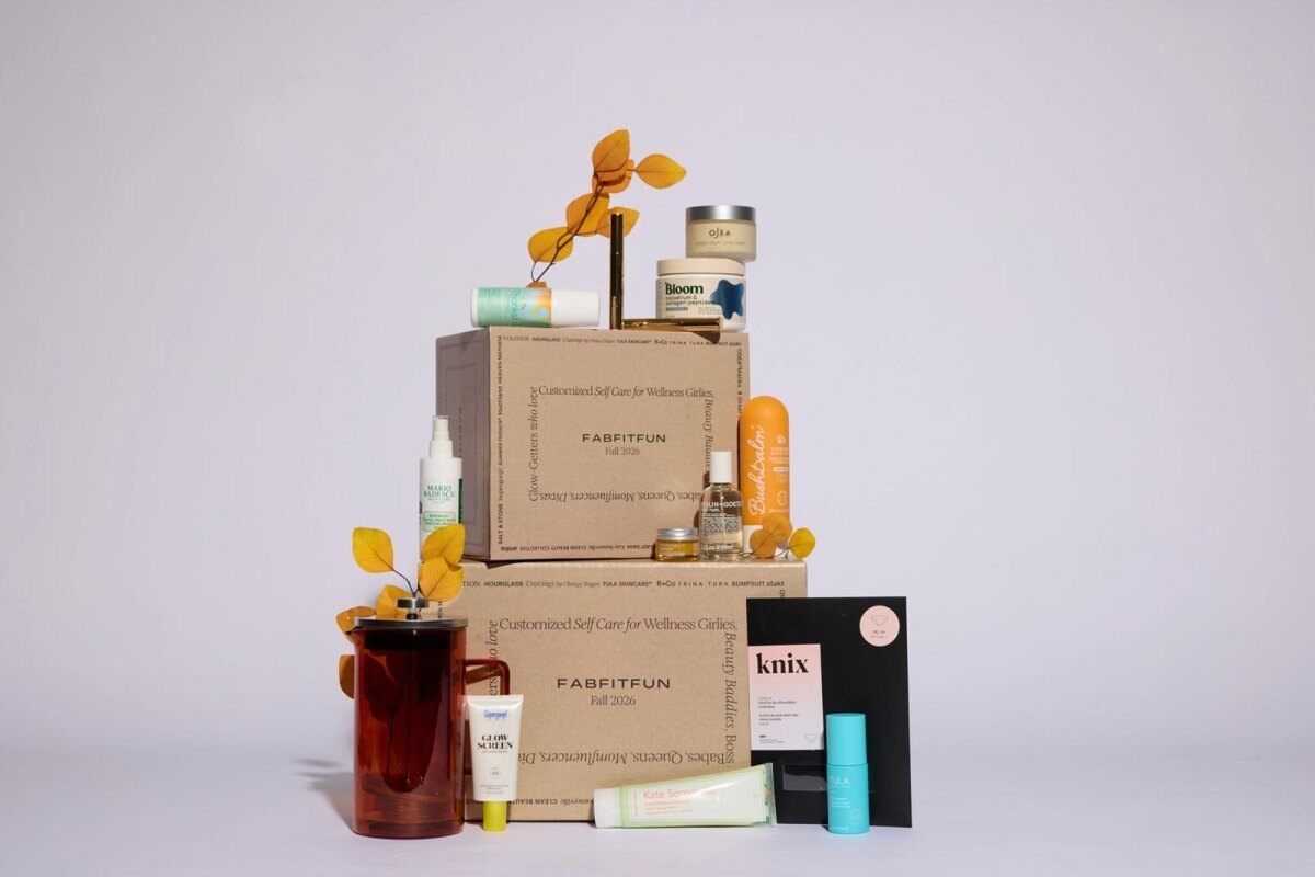Two stacked FabFitFun seasonal boxes surrounded by beauty, wellness and home products, from an official FabFitFun photo