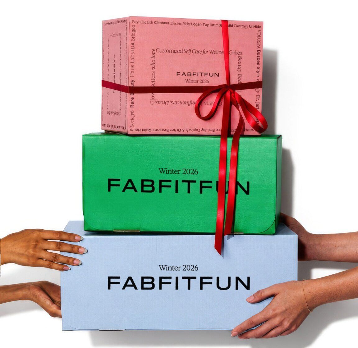 Three stacked FabFitFun Winter 2026 boxes in pink, green and blue tied with a red ribbon