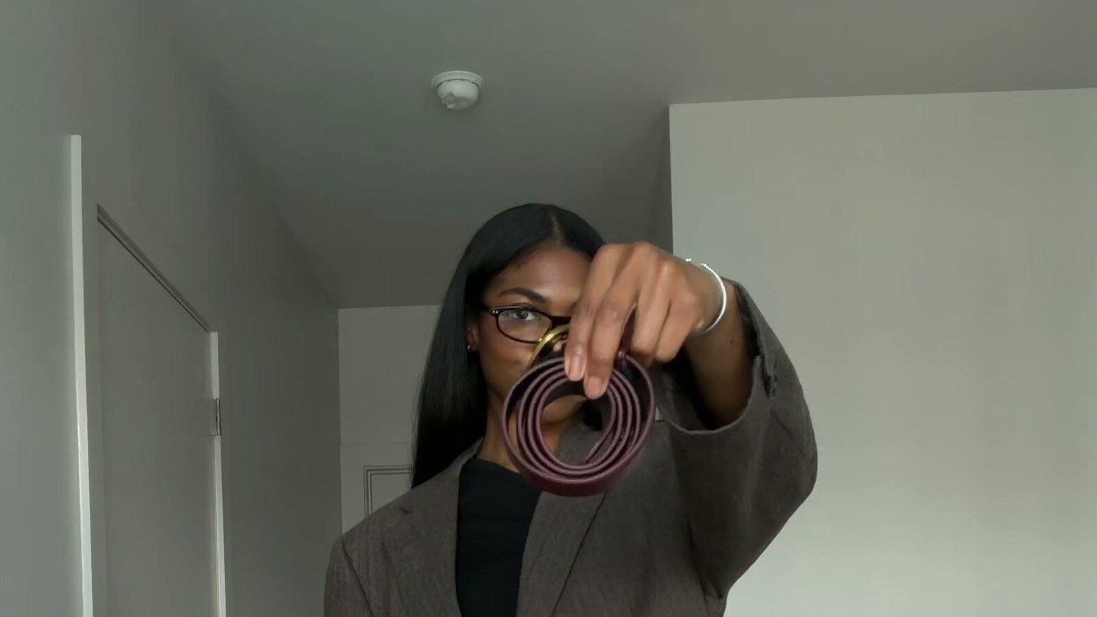 Model holding the 8 Other Reasons Harper Belt in Wine from the FabFitFun Winter 2026 box