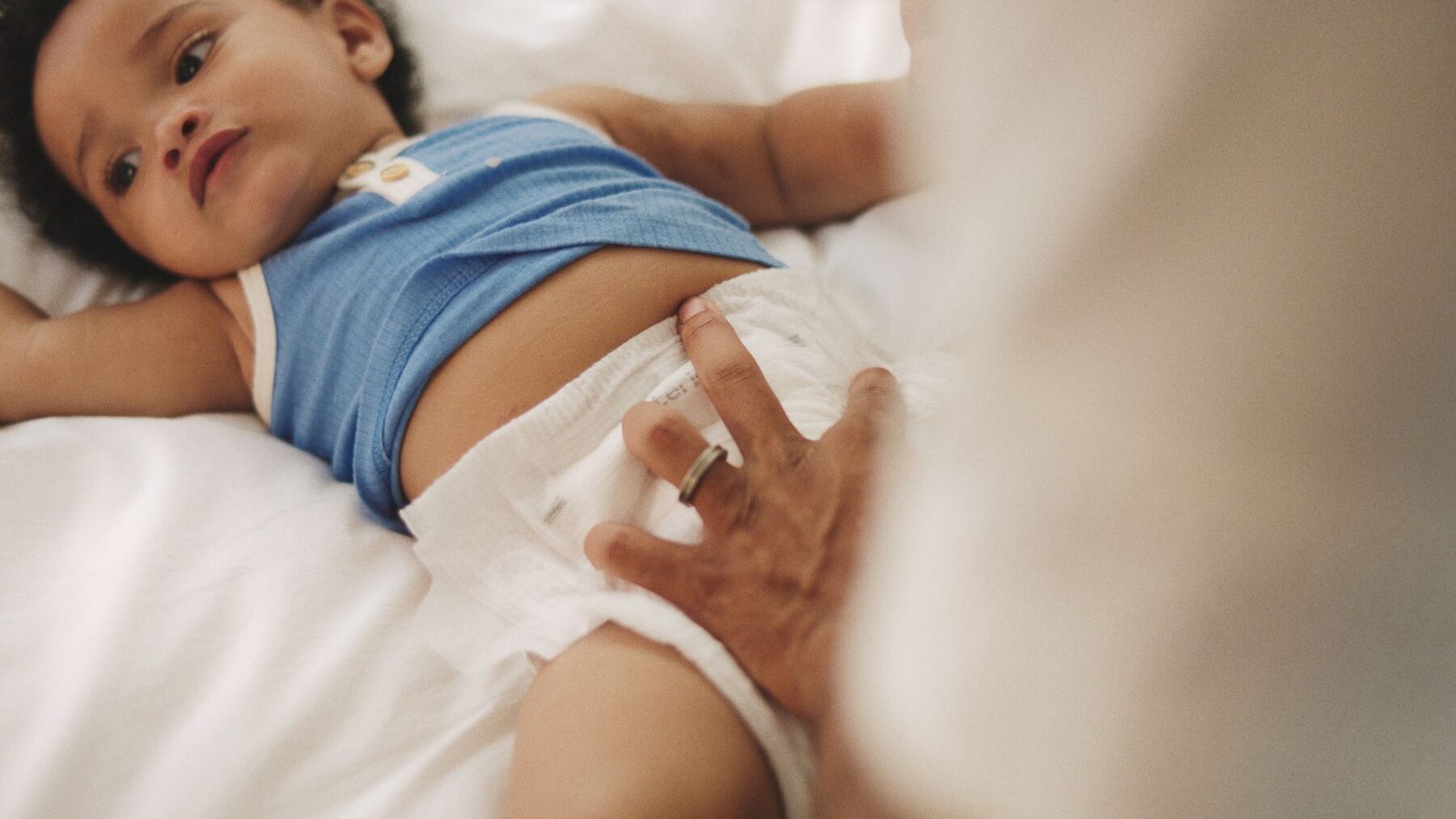 Parent changing a baby wearing a Coterie diaper