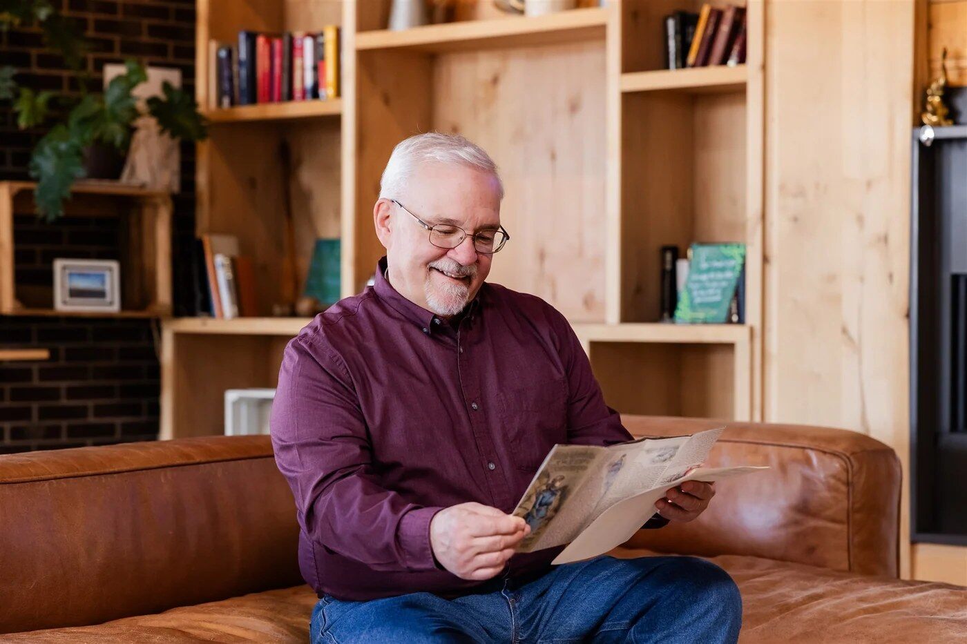 Man reading a History By Mail letter on the couch
