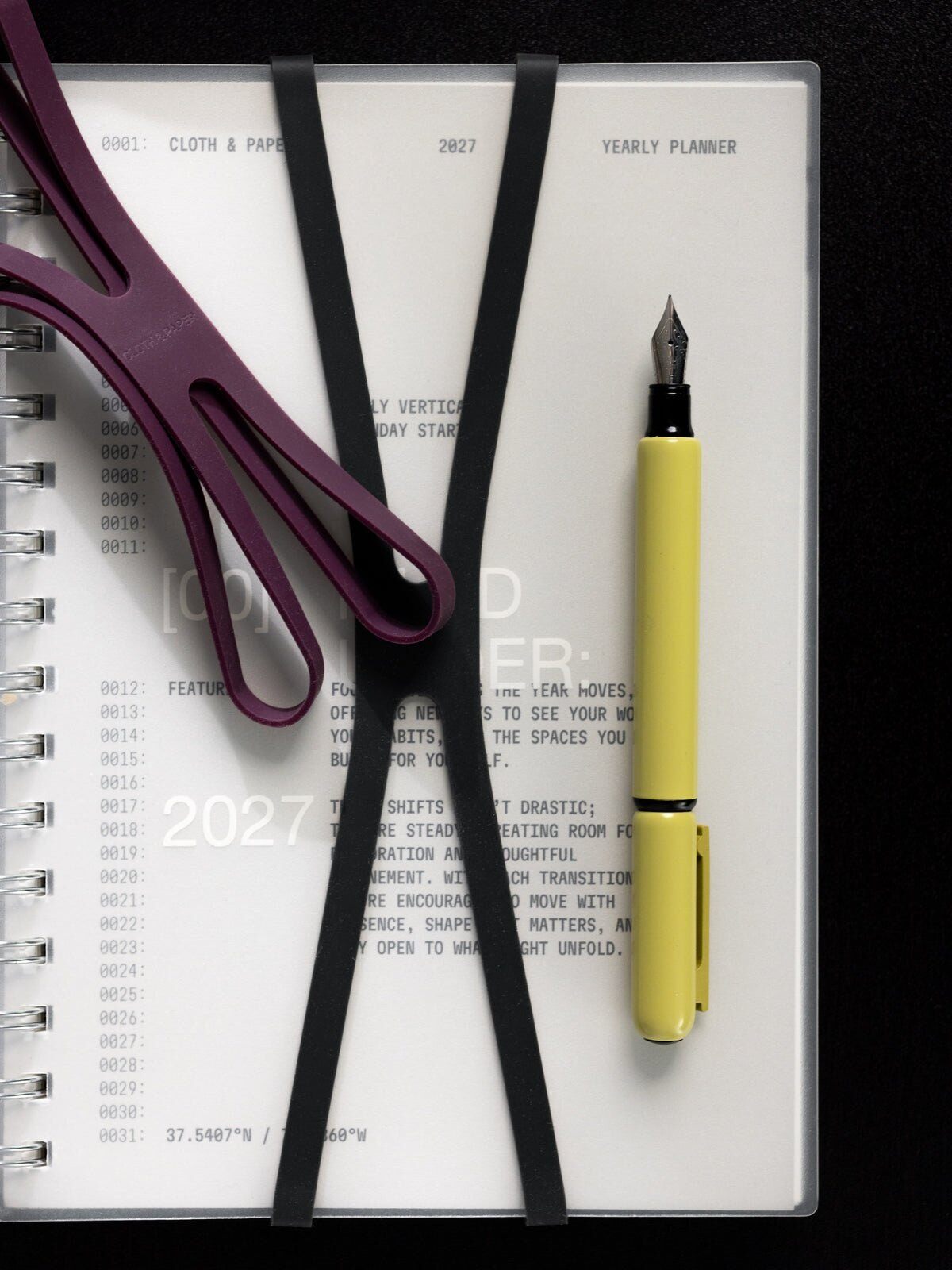 Cloth and Paper 2027 dated spiral planner with planner closure bands and a yellow pen from the November 2026 Intention Box