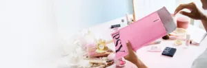 Woman opening her pink IPSY Glam Bag at her vanity