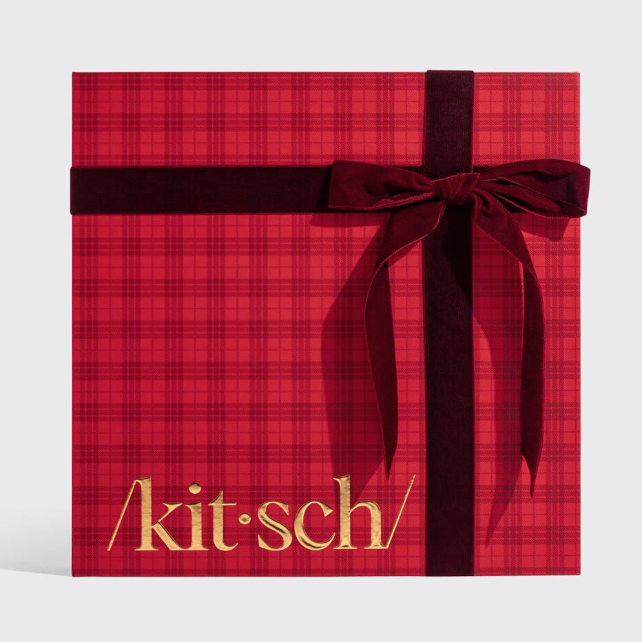 Kitsch Holiday Advent Calendar 2026 closed in a red plaid gift box with a velvet bow