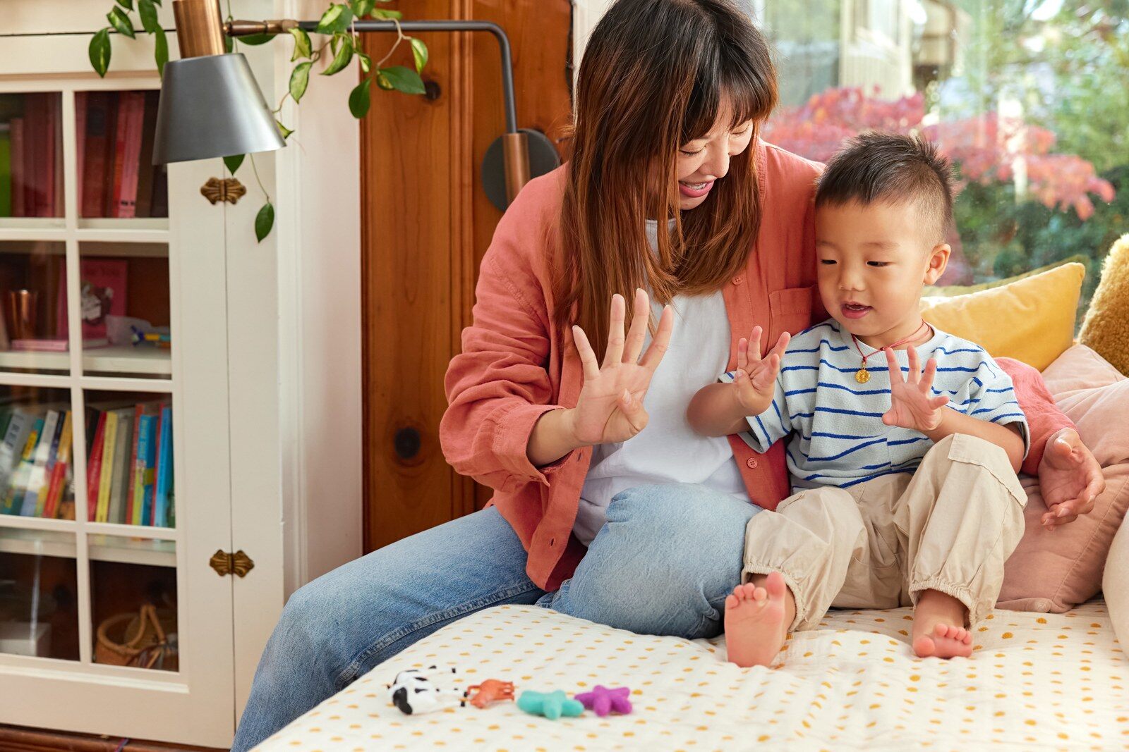 Parent playing with a baby and Lovevery toys at home
