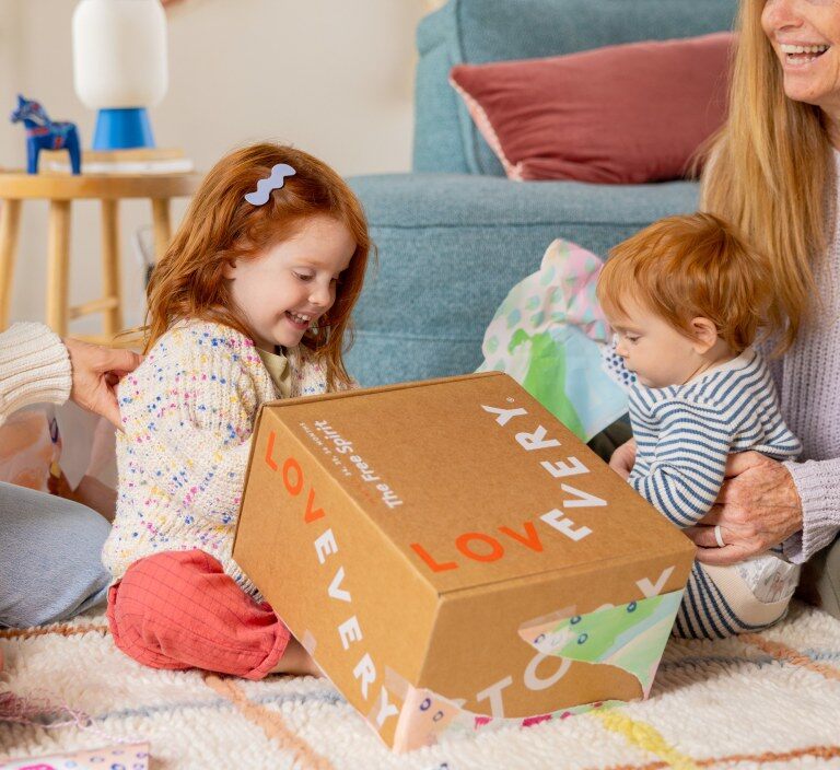 Child opening a Lovevery Play Kit box