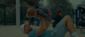 Father lifting his child in the air at a park, MUDWTR morning ritual lifestyle