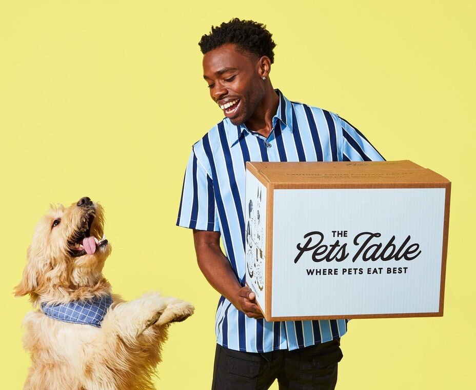 Man with his dog and a The Pets Table box