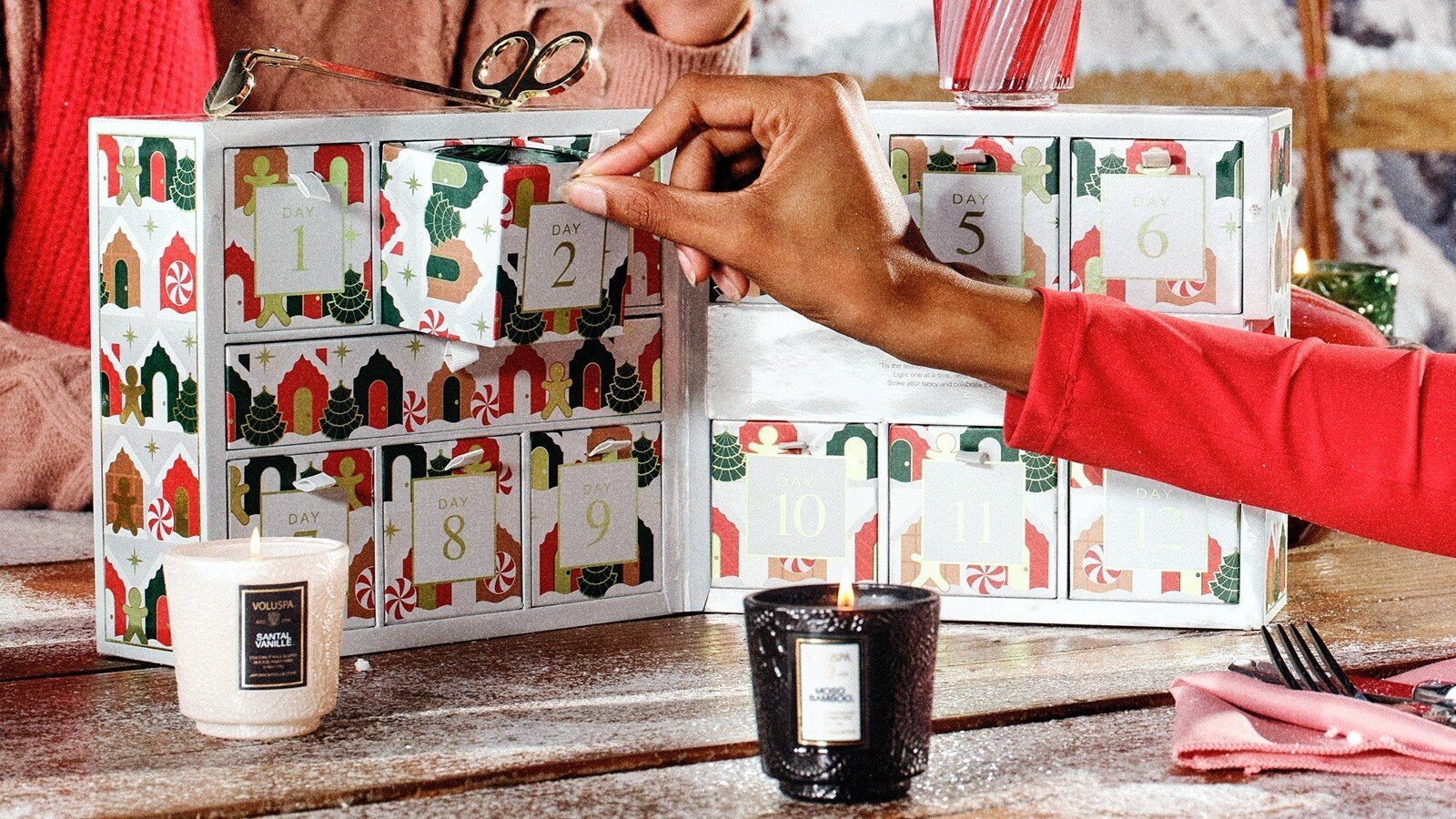 A hand opening a drawer of the Voluspa 12 Day Alpine Advent Calendar 2026